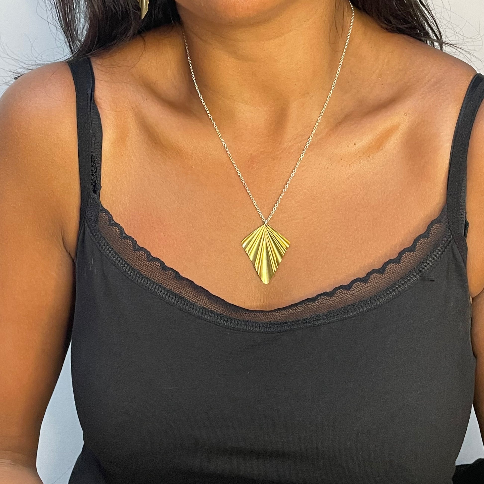 large brass fan necklace on model